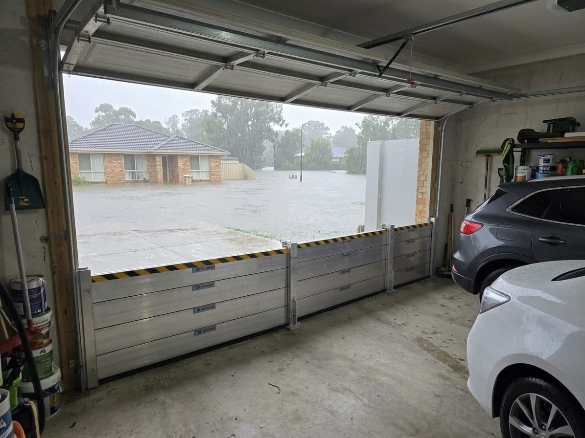 Aluminum flood barrier across a double garage door